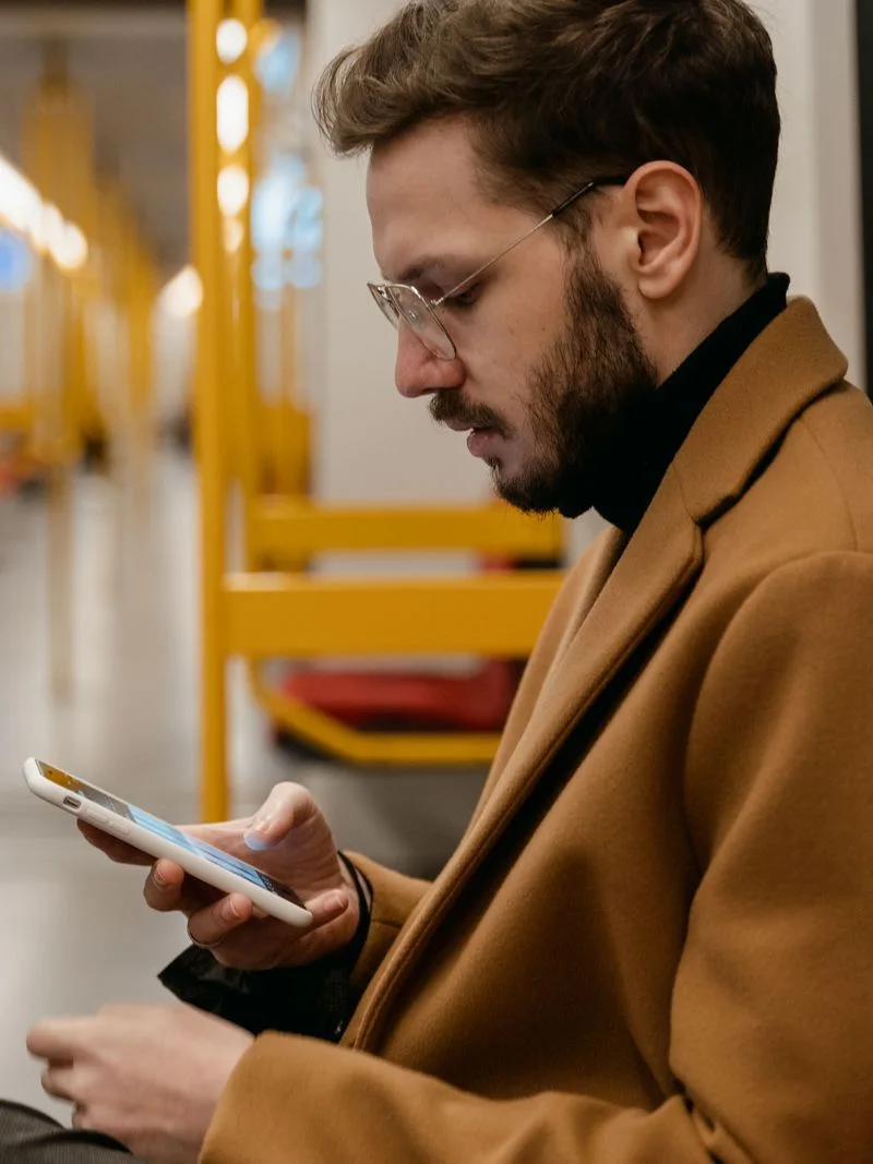 A man reading on his phone on a train